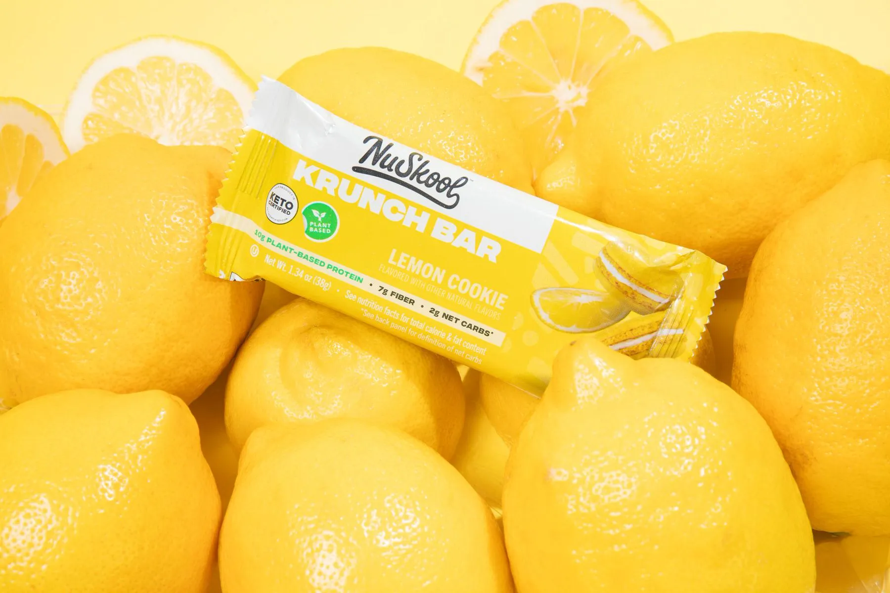 a lemon protein power bar on top of a bunch of lemons 
